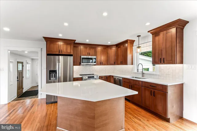 a kitchen with stainless steel appliances a sink and a refrigerator