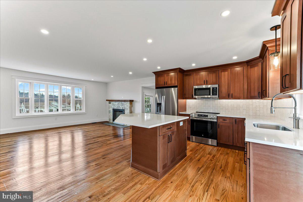 919 South Concord Road West Chester, PA 19382 - Photo 7 of 31 a large kitchen with stainless steel appliances granite countertop a stove a sink dishwasher and a refrigerator with wooden floor