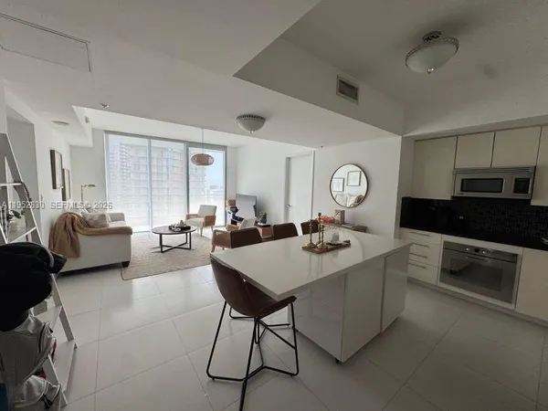 a living room with furniture and view of kitchen