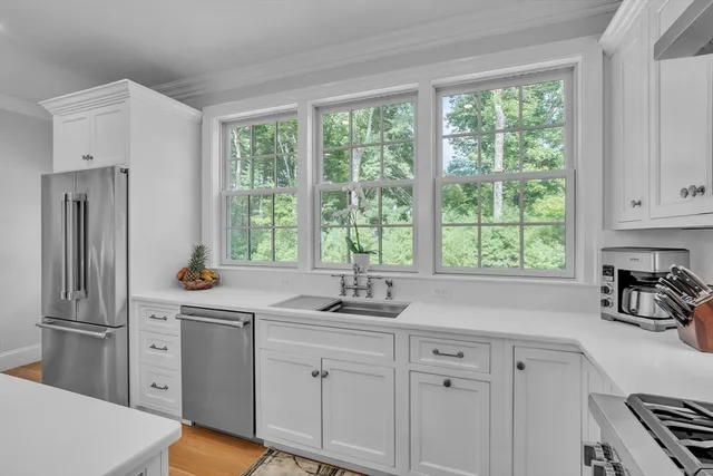 a kitchen with white cabinets and a window