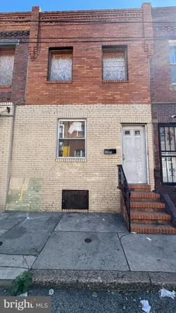 a brick building with a bench in front of door