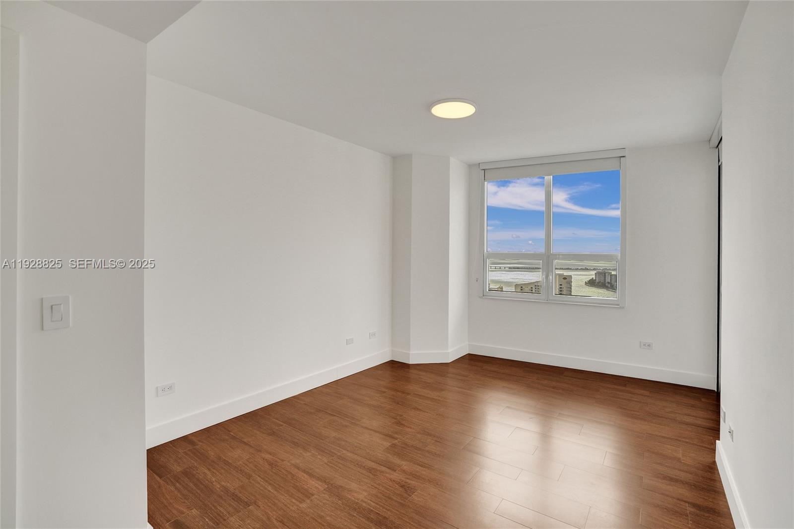 848 Brickell Key Drive, Unit 3206 Miami, FL 33131 - Photo 39 of 93 an empty room with wooden floor and windows