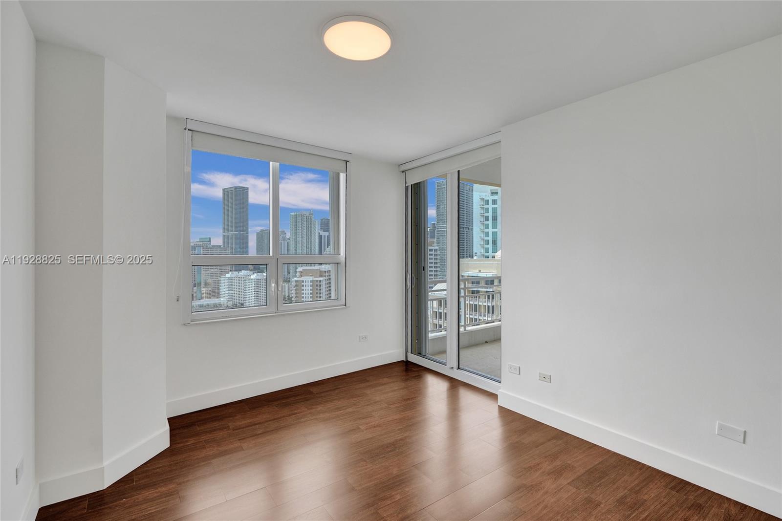 848 Brickell Key Drive, Unit 3206 Miami, FL 33131 - Photo 40 of 93 a view of an empty room with wooden floor and a window