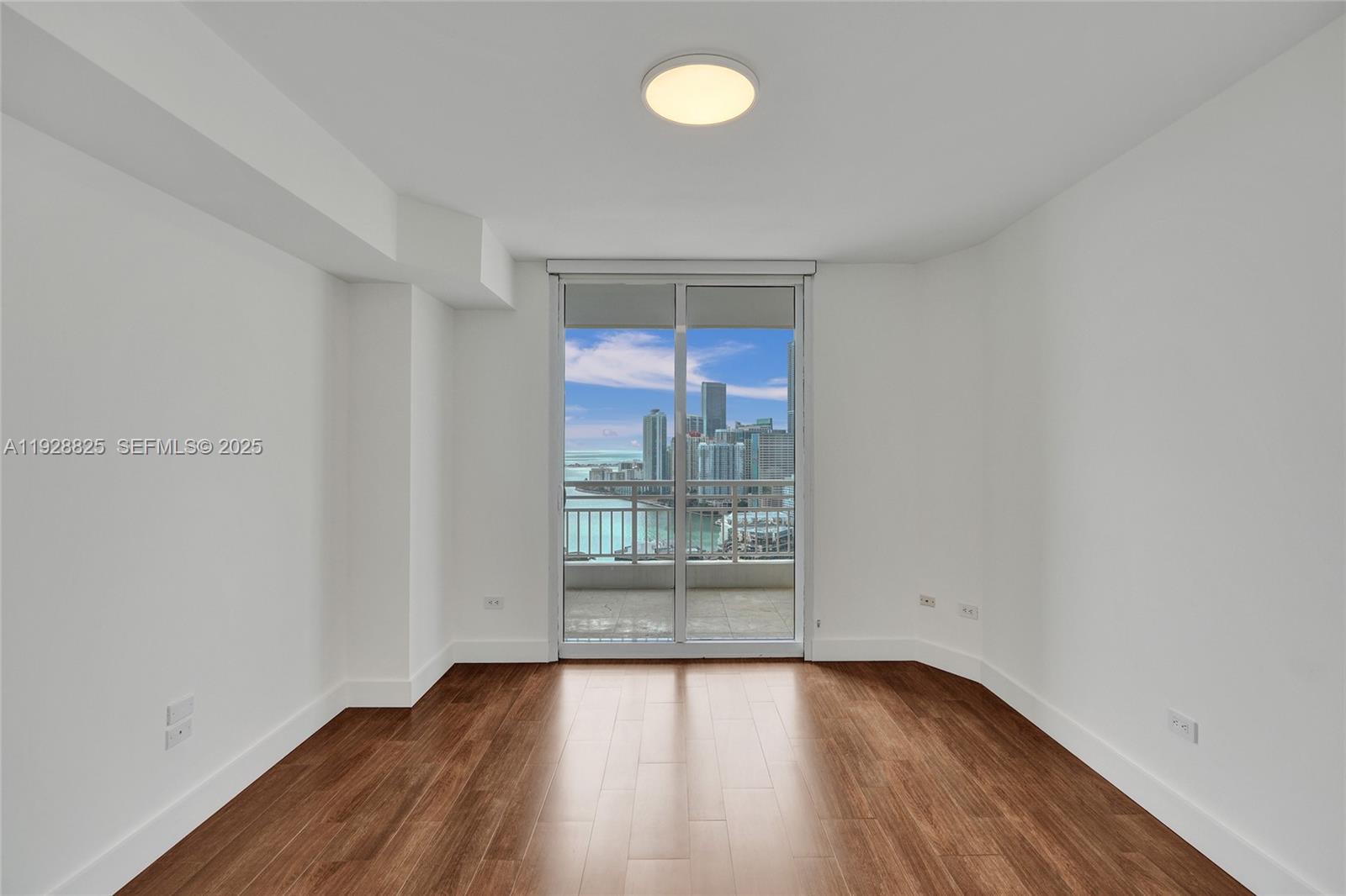 848 Brickell Key Drive, Unit 3206 Miami, FL 33131 - Photo 46 of 93 an empty room with wooden floor and windows