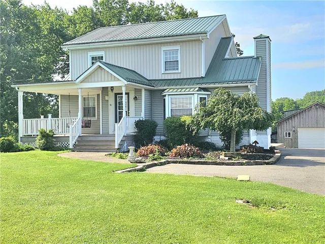 a front view of a house with a yard table and chairs