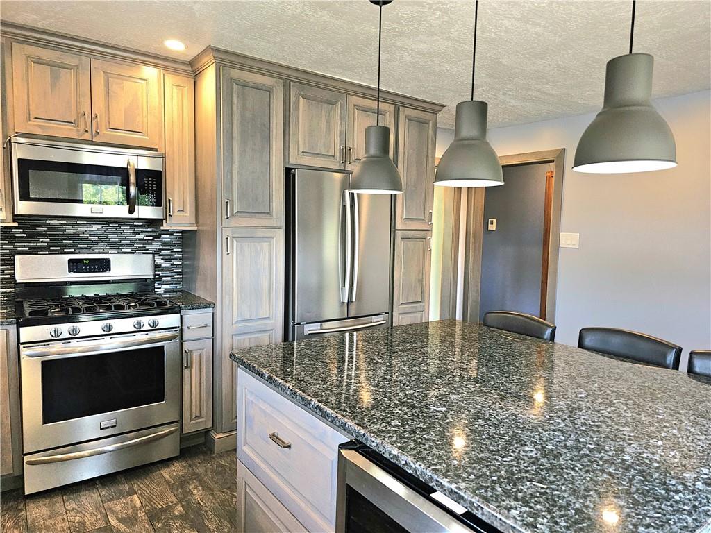 342 Concord Church Road Beaver Falls, PA 15010 - Photo 22 of 44 a kitchen with stainless steel appliances granite countertop a stove a refrigerator and a microwave