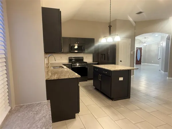 a kitchen with a sink a counter top space and cabinets
