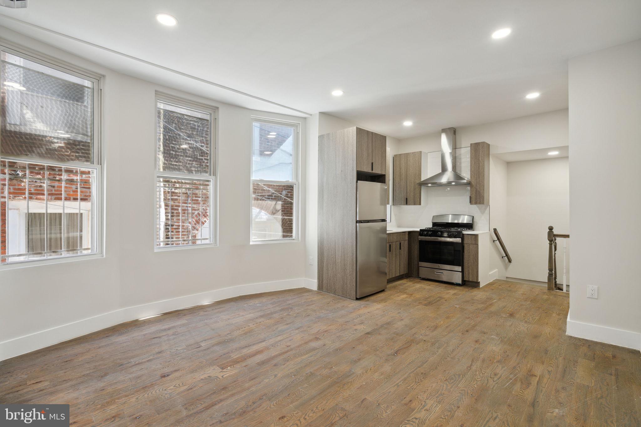 1908 Pine Street, Unit 2 Philadelphia, PA 19103 - Photo 5 of 16 a kitchen with stainless steel appliances kitchen island granite countertop a refrigerator and a sink