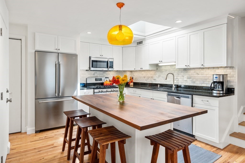 30 Cross Street, Unit 2 Boston, MA 02129 - Photo 3 of 18 a kitchen with stainless steel appliances granite countertop a refrigerator a sink a stove and white cabinets with wooden floor