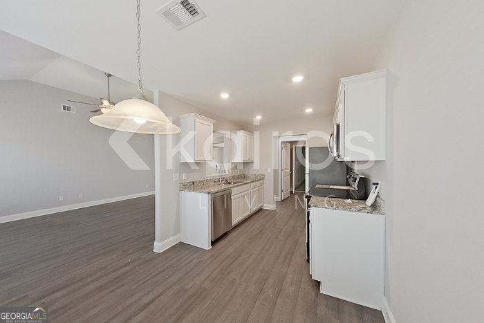228 Western Red Cedar Drive Springfield, GA 31329 - Photo 6 of 27 a kitchen with a sink stainless steel appliances and wooden floor