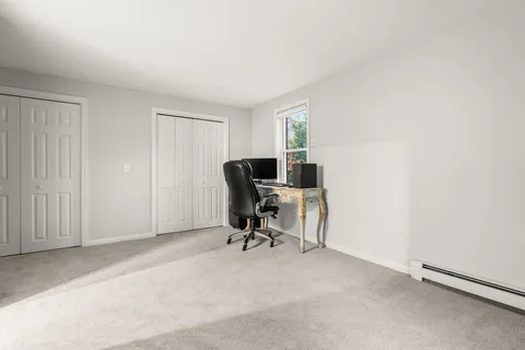 a view of swimming pool with lawn chairs and large trees