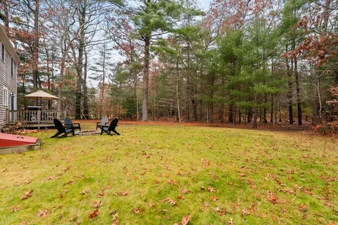 a front view of a house with yard and trees