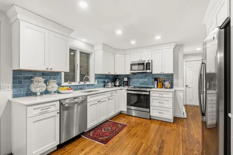 a kitchen with a refrigerator a table and chairs