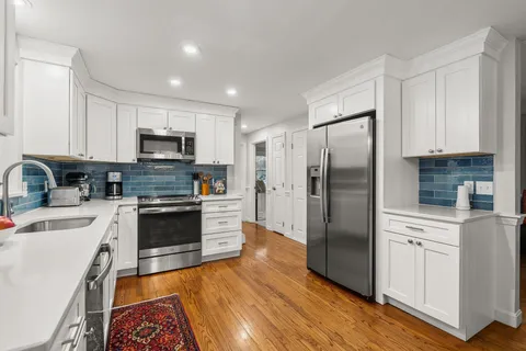 a open kitchen with granite countertop a sink cabinets and wooden floor