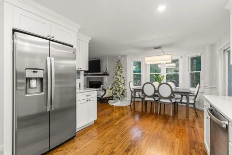 a dining room with furniture a chandelier and wooden floor