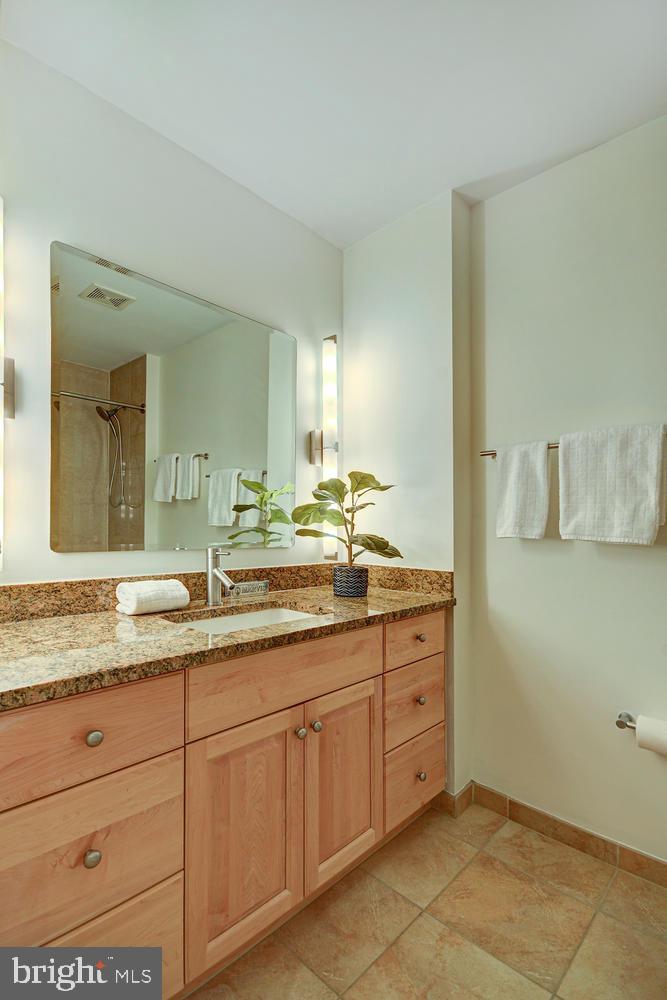 811 4th Street Northwest, Unit 507 Washington, DC 20001 - Photo 13 of 23 a bathroom with a granite countertop sink mirror and cabinets