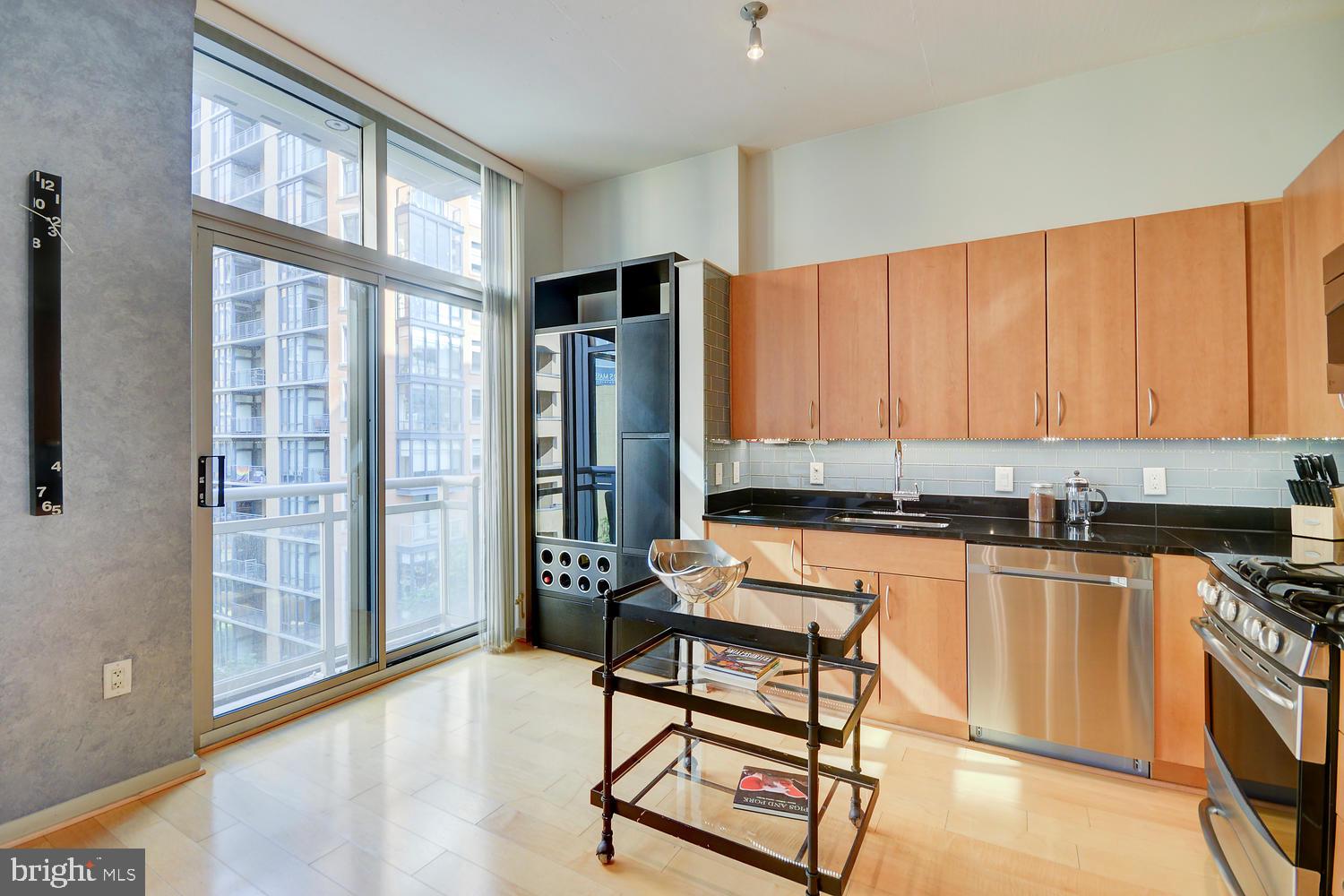 811 4th Street Northwest, Unit 507 Washington, DC 20001 - Photo 9 of 23 a kitchen with stainless steel appliances granite countertop a stove a refrigerator a sink and white cabinets with wooden floor