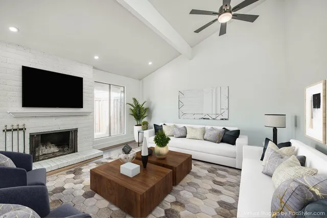 a living room with furniture a fireplace and a flat screen tv