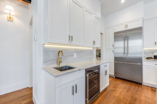 a kitchen with stainless steel appliances granite countertop a sink and a refrigerator