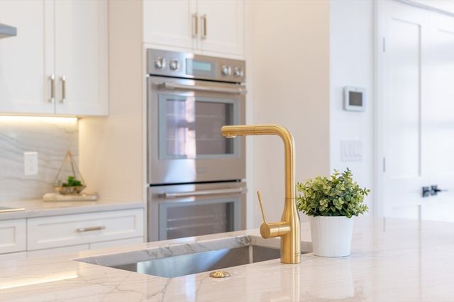 a kitchen with a refrigerator and a potted plant