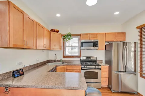a kitchen with stainless steel appliances granite countertop a refrigerator sink and stove