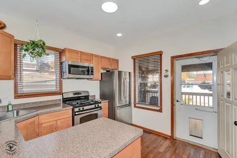a kitchen with stainless steel appliances granite countertop a refrigerator and a sink