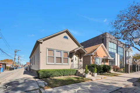 a view of a house next to a yard with road and trees