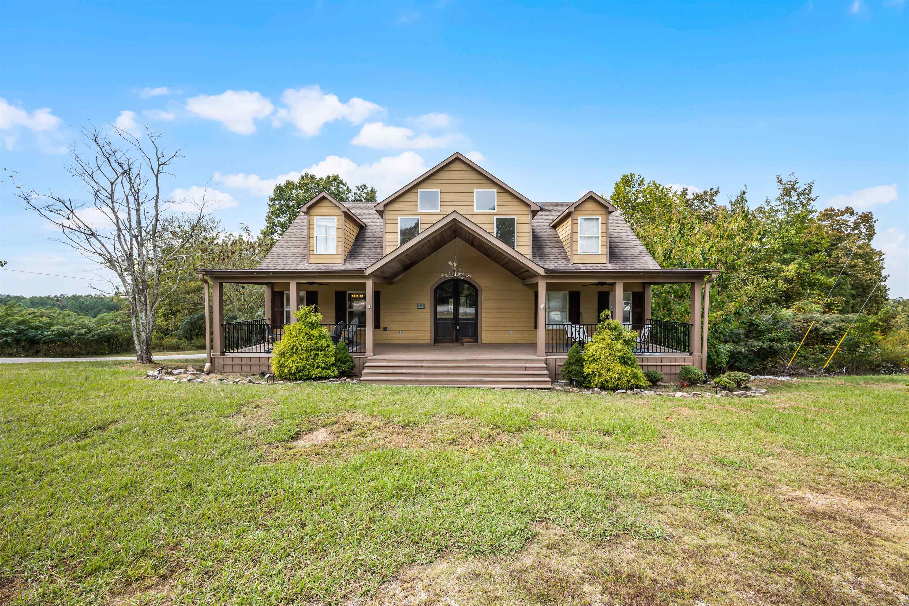 View of front of house featuring a porch, a front yard, and roof with shingles