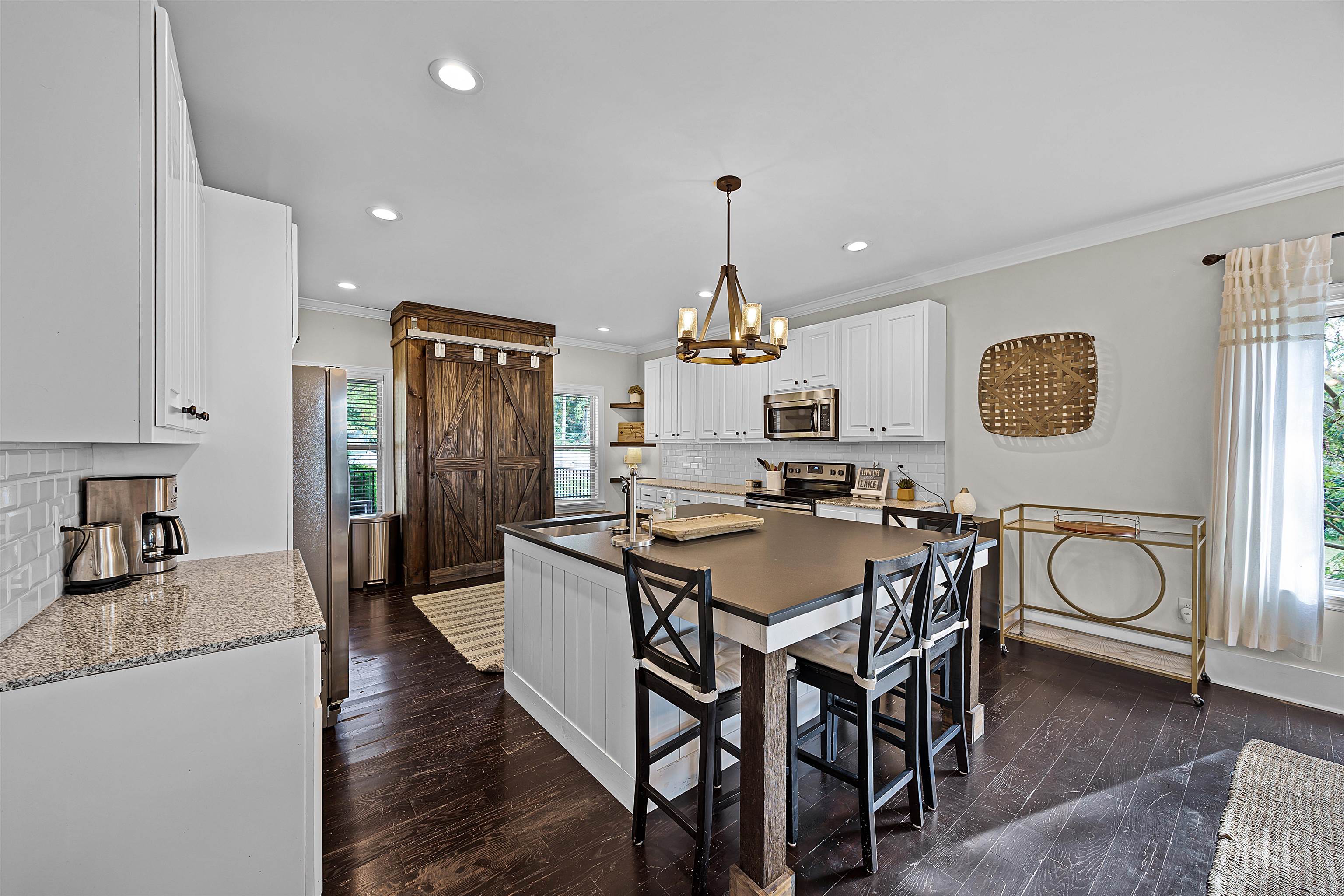 939 Eagle Point Drive Cherokee, AL 35616 - Photo 11 of 40 a kitchen with stainless steel appliances a dining table chairs and stove top oven