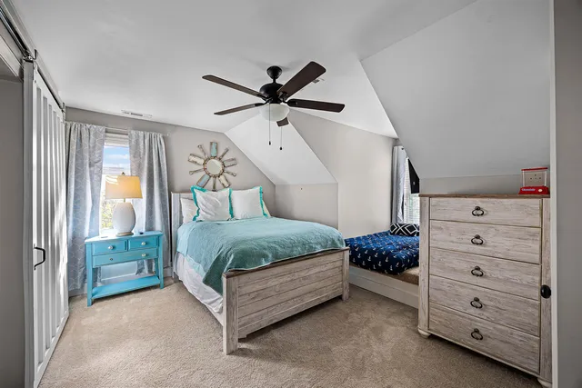 a bedroom with a bed dresser and a window