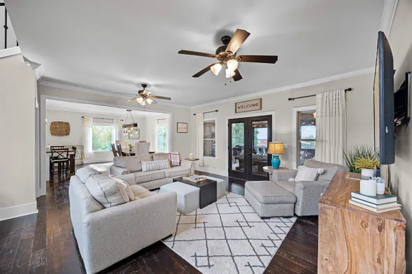 a living room with furniture a ceiling fan and a flat screen tv