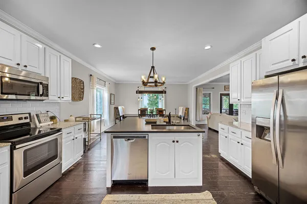a kitchen with stainless steel appliances a stove refrigerator sink and cabinets