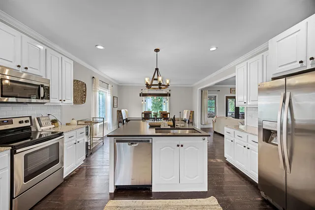 a kitchen with stainless steel appliances a stove refrigerator sink and cabinets