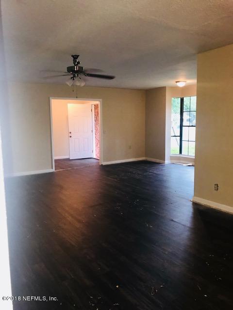 5875 Spellman Road Jacksonville, FL 32209 - Photo 4 of 14 a view of an empty room with wooden floor and a window