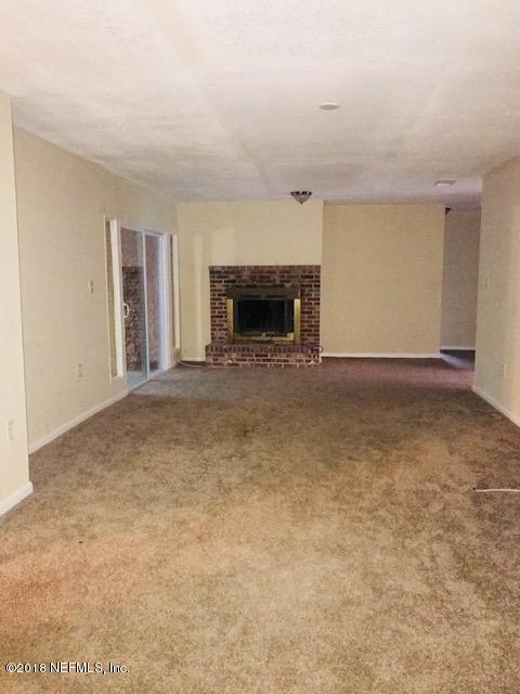 5875 Spellman Road Jacksonville, FL 32209 - Photo 5 of 14 an empty room with a fireplace and a window