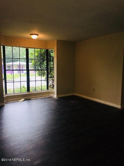 5875 Spellman Road Jacksonville, FL 32209 - Photo 7 of 14 a view of an empty room with wooden floor and a window