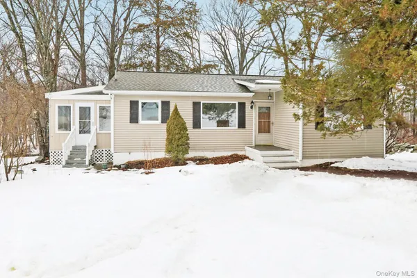 a front view of a house with a yard covered in snow