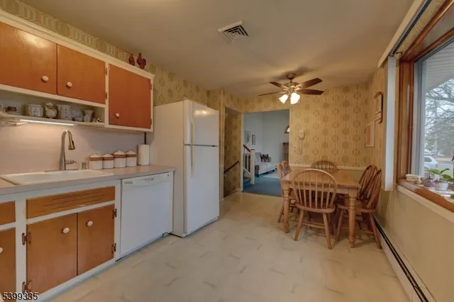 a kitchen with a refrigerator a sink and chairs