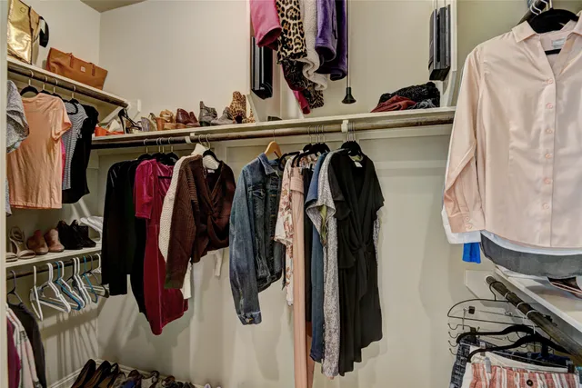 a view of walk in closet with clothes and shoes