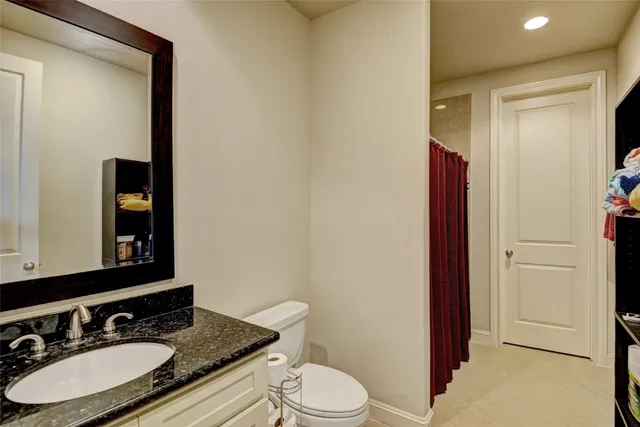 a bathroom with a granite countertop sink and a mirror with toilet