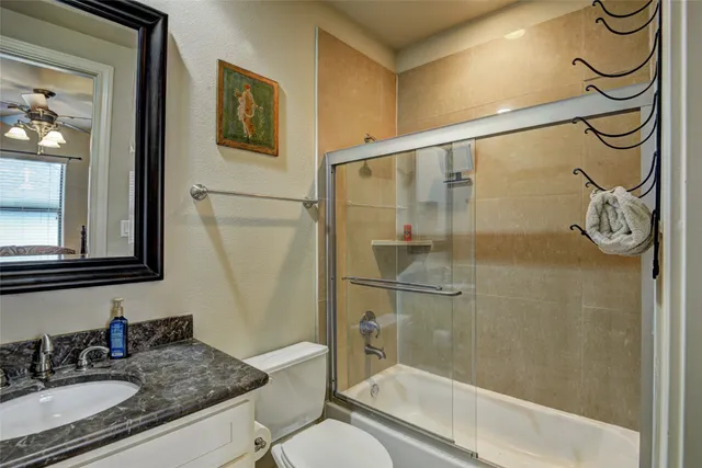 a bathroom with a granite countertop sink mirror toilet and shower