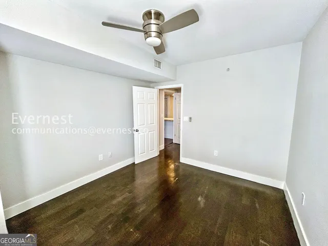 a view of room with hardwood floor and ceiling fan