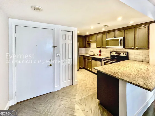 a kitchen with stainless steel appliances granite countertop a refrigerator and a sink