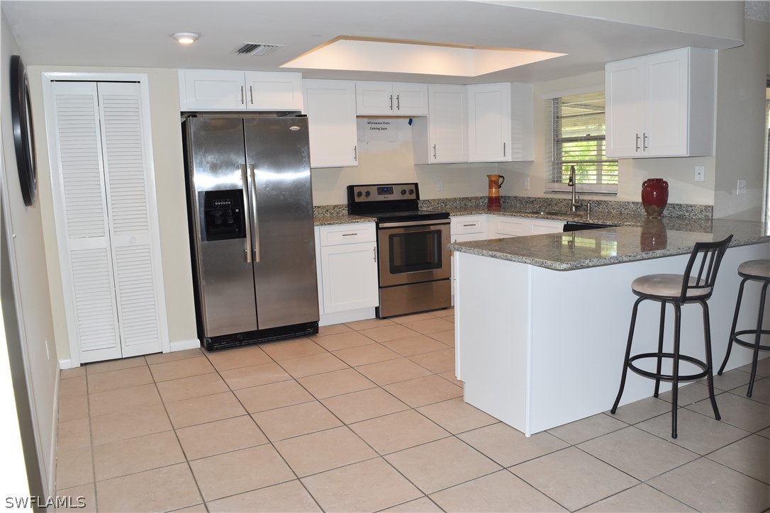 17404 Homewood Road Fort Myers, FL 33967 - Photo 5 of 26 a kitchen with stainless steel appliances granite countertop a refrigerator sink and cabinets