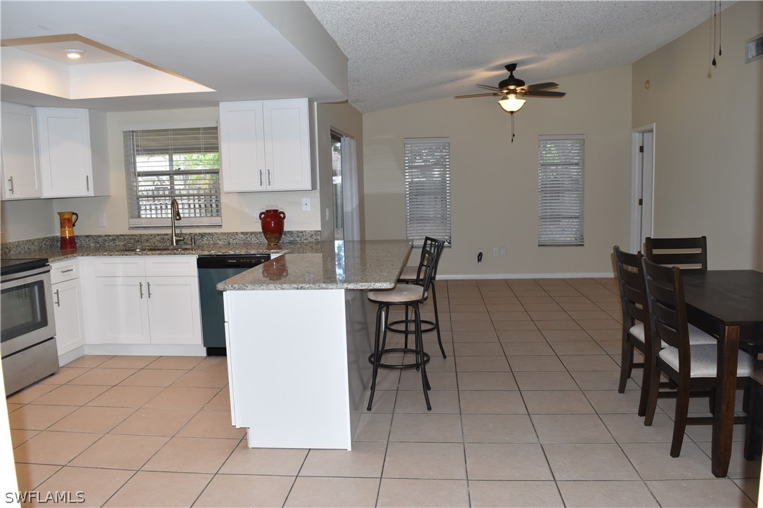 17404 Homewood Road Fort Myers, FL 33967 - Photo 8 of 26 a kitchen with a table chairs and a refrigerator