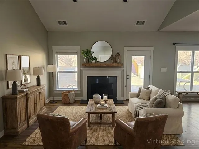 a living room with furniture a fireplace and a large window