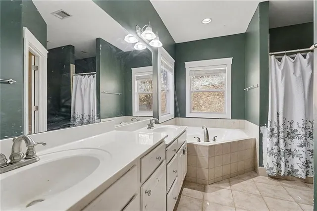 a spacious bathroom with sink shower and bathtub