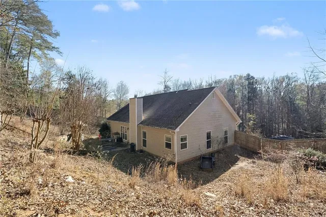 a view of house with backyard and trees