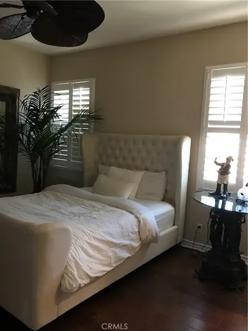 a bedroom with a bed wall painting and a window