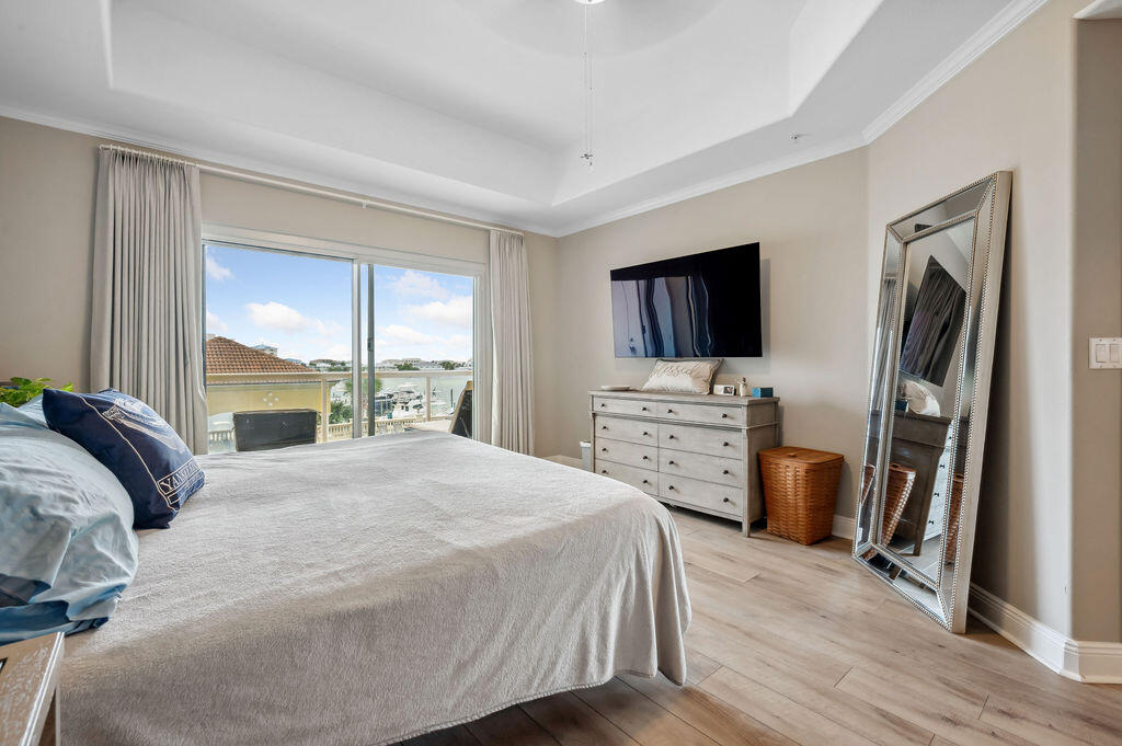 770 Harbor Boulevard, Unit 1D Destin, FL 32541 - Photo 16 of 59 a bedroom with a bed flat screen tv and a window